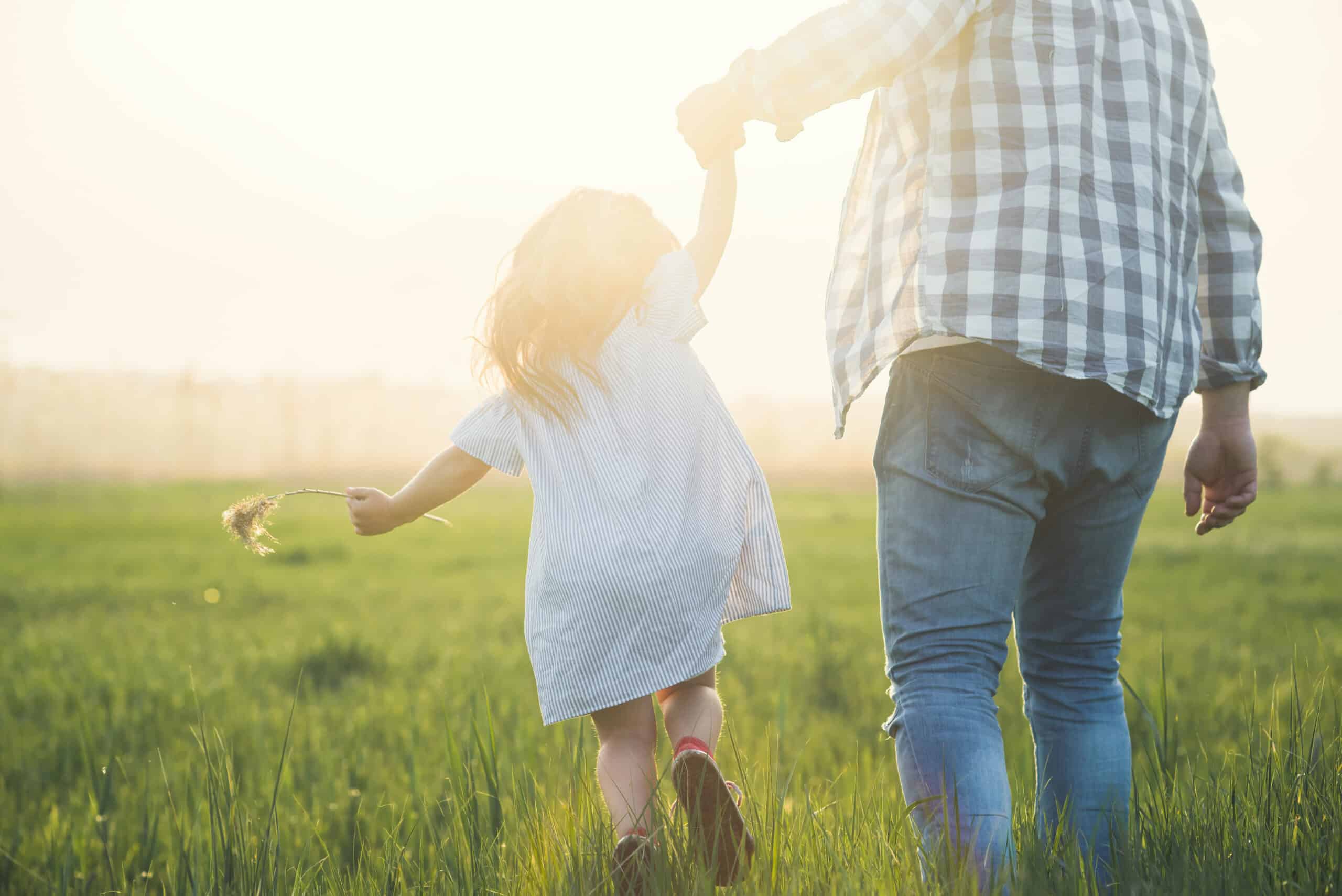 father and child walking on sunset